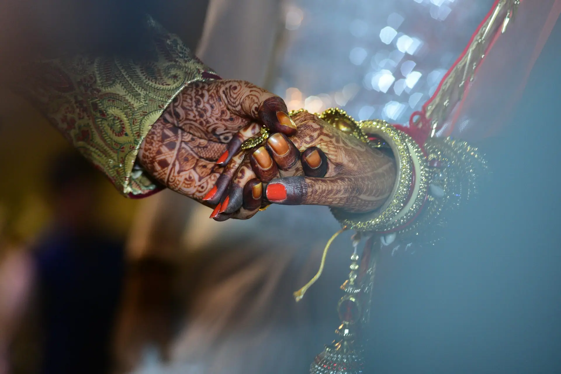 Home A beautiful capture of mehndi-decorated hands symbolizing love and tradition in a wedding ceremony.