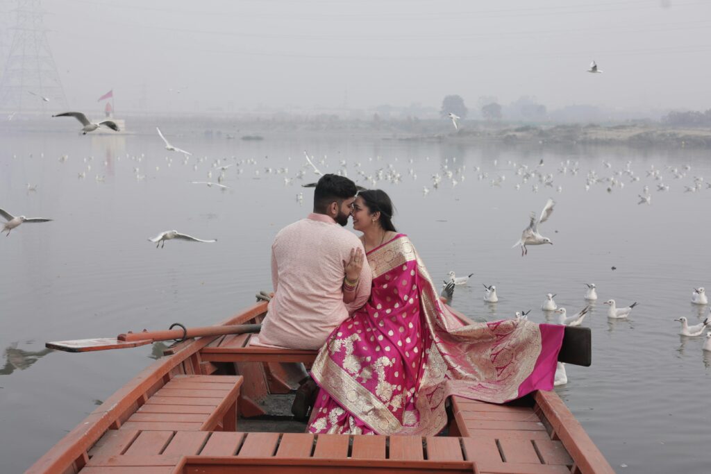 A couple enjoys a serene boat ride surrounded by seagulls on a misty day.